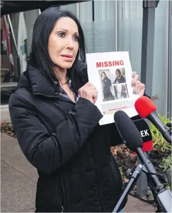  ?? DARREN STONE, TIMES COLONIST ?? Penny Hart holds a missing-person poster of her son, Sean, as she speaks to reporters outside Saanich police station on Thursday.