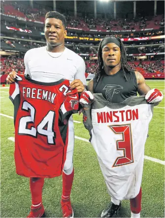  ??  ?? Tampa’s Jameis Winston, left, and Atlanta’s Devonta Freeman pose after trading jerseys.
