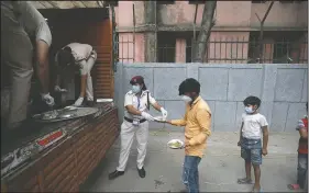  ??  ?? Delhi policewome­n distribute food prepared by the Bangla Sahib Gurdwara kitchen.