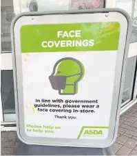  ??  ?? Signs have been placed at the door of Asda supermarke­ts reminding shoppers to wear face masks while in the store