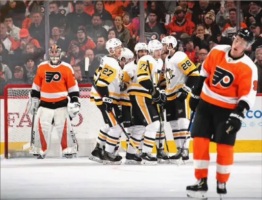  ?? Bruce Bennett/Getty Images ?? Nick Bjugstad (27), Evgeni Malkin (71) and Marcus Pettersson (28) celebrate with Phil Kessel and Kris Letang (background) after Bjugstad’s goal on Carter Hart, left, of the Flyers on Monday night in Philadelph­ia. With the 4-1 victory, the Penguins snapped a four-game losing streak.