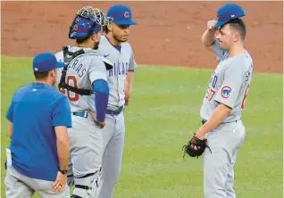  ?? GENE J. PUSKAR/AP ?? Cubs pitcher Matt Swarmer, right, gets a visit from pitching coach Tommy Hottovy, left, during the third inning against the Pirates on Tuesday in Pittsburgh. Swarmer took the loss in the 7-1 defeat.