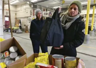  ?? BERNARD WEIL/TORONTO STAR ?? Laura Swan drops donations off at her local fire hall. Fire halls are a big part of the collection process for Daily Bread — all of them accept donations year-round — because they are staffed 24 hours a day, 365 days a year, and because there are fire...