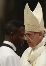  ?? GREGORIO BORGIA — THE ASSOCIATED PRESS ?? John Ogah walks past Pope Francis after being baptized during a solemn Easter vigil ceremony in St. Peter’s Basilica at the Vatican, Saturday.