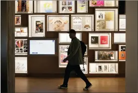  ?? SUE OGROCKI — THE ASSOCIATED PRESS ?? A man walks past a portion of the archive wall at the Bob Dylan Center in Tulsa, Okla. A report released Tuesday offers a comprehens­ive look at American philanthro­py.