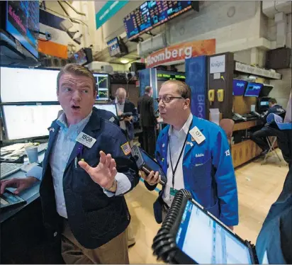  ?? — BLOOMBERG ?? Traders work at the New York Stock Exchange on Friday. Stocks fell in the U.S. and Canada, erasing early gains.