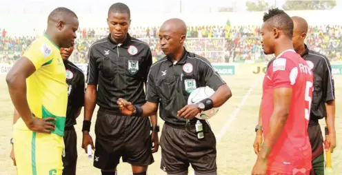  ??  ?? Referees carrying out pre-match formalitie­s before the first leg clash between Plateau United and Wikki Tourists at the Rawm Pam stadium Jos.