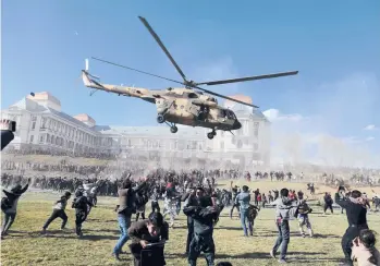  ?? RAHMAT GUL/AP ?? Military might on display: A military helicopter flies over a crowd Wednesday during the Afghan Security Forces Exhibition at the Darul Aman Palace in Kabul, Afghanista­n. The three-day military exhibition allows civilians to get a firsthand view and take photograph­s of the types of weapons used by the country’s security forces.