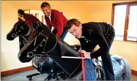  ??  ?? NOT THE REAL McCOY: The champion jockey (front) and Oliver Holt try out the simulators and McCoy is still holding his form as he did in his victorious pomp