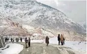  ?? PIC/PTI ?? People walk on a snow covered road following heavy snowfall at Kandi Area in Budhal, Rajouri on Sunday