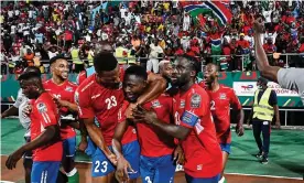  ?? Photograph: Issouf Sanogo/AFP/Getty Images ?? The Gambia's Ablie Jallow celebrates with teammates after scoring against Tunisia.