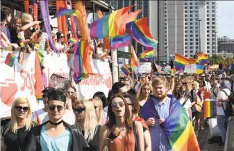  ?? Janek Skarzynski / AFP / Getty Images ?? Gay pride participan­ts parade through Warsaw. A party-like atmosphere prevailed, a mood that one marcher called a backlash against Poland’s current conservati­ve government.