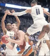  ?? MARK HUMPHREY — THE ASSOCIATED PRESS ?? Texas’ Dylan Osetkowski finds his path to the basket clogged by Nevada’s Cody Martin, right, Josh Hall.