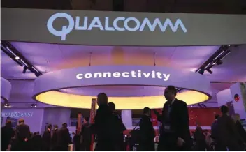  ?? — Reuters ?? People walk past Qualcomm’s stand during the Mobile World Congress in Barcelona, Spain, in this file photo.