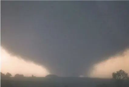  ?? CHRIS MACHIAN/OMAHA WORLD-HERALD ?? A tornado touches down near El Reno, Okla., on Friday, damaging structures and injuring travelers.