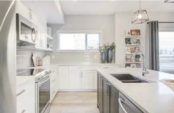  ?? CEDARGLEN LIVING ?? The kitchen in the Banff townhome by Cedarglen Living is formatted in an L-shaped design and has five floating shelves, perfect for all your family’s cookbooks.