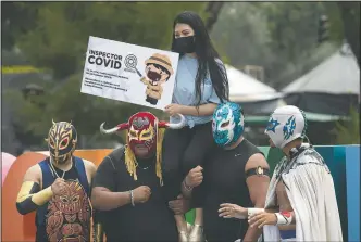  ??  ?? Lucha Libre fighters pose for a photo during a campaign to promote the use of masks during the covid 19 pandemic in Xochimilco.