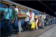  ??  ?? PACK-UP TIMEMigran­t workers in Ahmedabad take a train back home