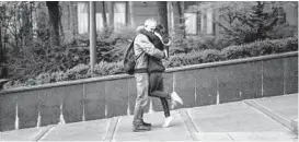  ?? ?? A couple on a street in central Kyiv. Threats from the ongoing war linger in the Ukrainian capital.