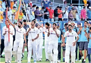  ??  ?? India players celebrate the Australia series victory by holding the national flag