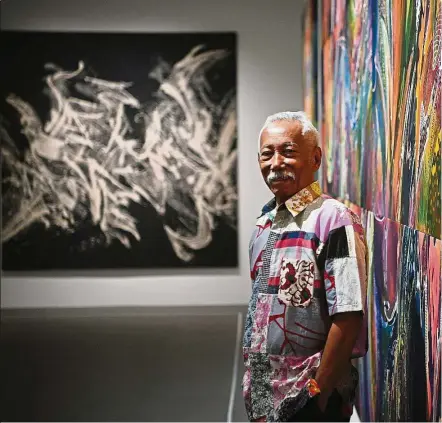  ??  ?? Sarkasi with his artworks View Of Life (right) and Light (background) at the National University of Singapore Museum. — ST