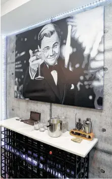  ?? Michael Wyke / Contributo­r ?? The bar by the kitchen in Zach Crager’s apartment features art of Leonardo DiCaprio in “The Great Gatsby.”