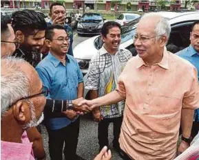  ?? SULAIMAN PIC BY MUHAMMAD ?? Former prime minister Datuk Seri Najib Razak greeting people during a walkabout in Shah Alam yesterday.