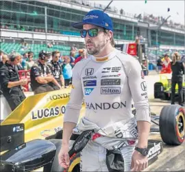  ?? Tannen Maury European Pressphoto Agency ?? SPANISH DRIVER Fernando Alonso walks in pit row while waiting his turn to qualify for the Indianapol­is 500. Alonso qualified fifth for Sunday’s race.