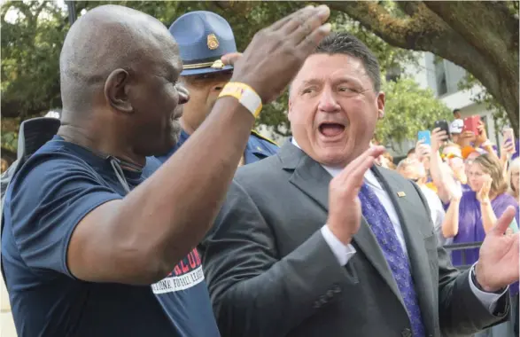  ?? (Photo by Matthew Hinton, AP) ?? LSU head coach Ed Orgeron, right, greets LSU alumni before an earlier game this season.