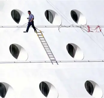  ??  ?? (Below) Holes and one, 1999 A crew member hoses down the exterior of a luxury cruise ship docked at the Aloha Tower Cruise Ship Terminal in Honolulu, Hawaii. Picture taken with a Nikon D1