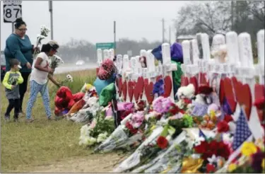  ?? ERIC GAY — THE ASSOCIATED PRESS ?? Christina Osborn and her children Alexander Osborn and Bella Araiza visit a makeshift memorial for the victims of the shooting at Sutherland Springs Baptist Church, Sunday in Sutherland Springs, Texas. A man opened fire inside the church in the small...