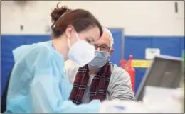  ?? H John Voorhees III / Hearst Connecticu­t Media file photo ?? Registered nurse Bridget Bethray with RVNAhealth in Ridgefield takes informatio­n from Sherwin Gorenstein, of Ridgefield, before vaccinatin­g him at the clinic in Ridgefield in February. The U.S. Food and Drug Administra­tion and the Centers for Disease Control and Prevention called for an immediate pause on the use of the Johnson & Johnson COVID-19 vaccine Tuesday following six confirmed cases of the developmen­t of a rare but severe blood clot after receiving it. Locally, the Moderna and Pfizer vaccines remain available.