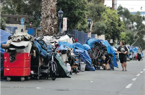  ?? PHOTOS: GREGORY BULL/THE ASSOCIATED PRESS ?? The number of people living outdoors in San Diego jumped more that 18 per cent this year. More than 400 makeshift shelters sprung up in the downtown area, where studio apartments go for around US$1,500 a month.