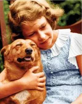  ?? ?? Smitten: A young Princess Elizabeth hugs a corgi in July 1936