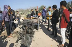  ?? Adel Hana / Associated Press ?? Palestinia­ns inspect a vehicle that was destroyed in an Israeli raid in Gaza that killed seven Palestinia­n militants, including a local Hamas commander.