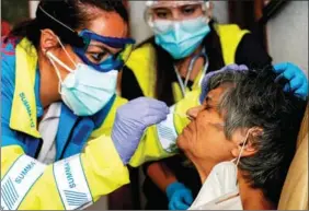  ?? JUAN MEDINA / REUTERS ?? A swab sample is taken by medical workers from an 86-year-old woman at her home in Madrid, Spain, on Oct 19.