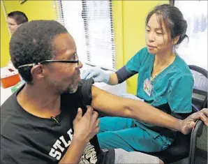  ?? Al Seib Los Angeles Times ?? A REGISTERED NURSE with Los Angeles Christian Health Centers administer­s a free hepatitis A vaccine on skid row. The highly contagious disease has spread quickly.