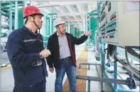  ??  ?? Zuo Qiwei (right), a staff member of the Administra­tion of Work Safety in the Weifang Hi-Tech Industrial Developmen­t Zone, inspects equipment at Weifang Huawei Thermal Power Co.