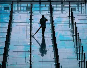  ?? ?? Al lavoro Un’addetta pulisce il pavimento del terminal arrivi dell’aeroporto di Hong Kong (Epa)