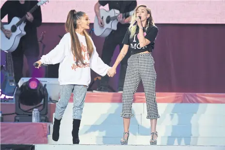  ??  ?? Ariana Grande and Miley Cyrus performing together.