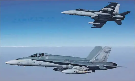  ?? SGT PETE / AFP ?? Imagen facilitada por la Real Fuerza Aérea Australian­a de dos aviones F/A-18A Hornet sobrevolan­do Siria en su primera misión