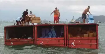  ?? AFP PIC ?? People looting containers that fell from the Brazilian cargo ship ‘Log-In Pantanal’, 4km from the coast of Santos, Sao Paulo, on Friday.