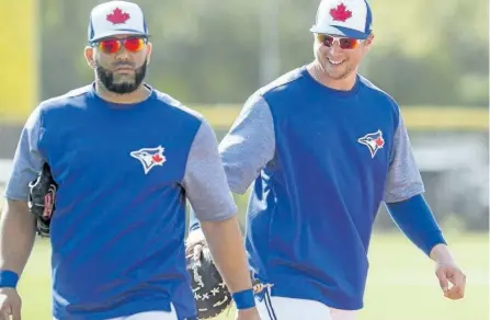  ?? FRANK GUNN/THE CANADIAN PRESS ?? Justin Smoak, right, gives his Blue Jays teammate Kendrys Morales a love tap as he passes by at spring training on Wednesday in Dunedin, Fla. Morales hopes a commitment to fitness during the offseason will help him elevate his game in 2018.