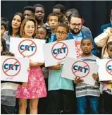  ?? DANIEL A. VARELA/AP ?? Kids holding signs against critical race theory stand on stage near Gov. Ron DeSantis as he addresses the crowd before publicly signing HB7, the “individual freedom,” also dubbed the “stop woke” bill, during a news conference at Mater Academy Charter Middle/ High School in Hialeah Gardens in April.