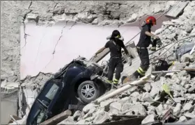  ?? AP PHOTO/GREGORIO BORGIA ?? Rescuers make their way through destroyed houses following Wednesday’s earthquake Thursday in Pescara Del Tronto, Italy.