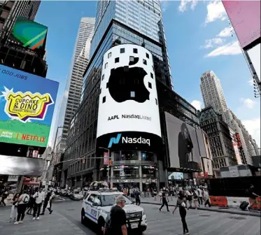  ?? — Bloomberg ?? Tech titan: The apple logo is displayed on a monitor outside the Nasdaq Marketsite in New york. The firm is under growing pressure to find new sources of revenue.
