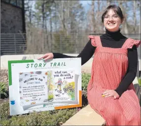  ?? Sally Carroll/Special to The Weekly Vista ?? Bella Vista Public Library Children's Assistant Ashdon Wilson displays the Story Trail launching soon.