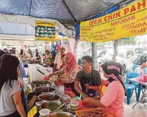  ?? PIC BY HAFIZ SOHAIMI ?? Sharifah Dun (third from right) serving customers at the Desa Pandan Ramadan Bazaar.