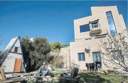  ?? TSAFRIR ABAYOV, AP ?? Moshe Gordon sits outside his guest house advertised on Airbnb in the Nofei Prat settlement. On Tuesday, Israel’s tourism minister threatened Airbnb with higher taxes over its decision to remove listings from Israeli settlement­s in the West Bank.