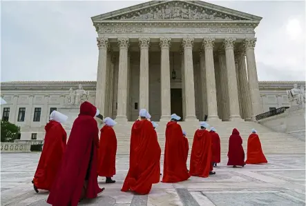  ?? AP ?? Handmaids’ march: Activists dressed as characters from ‘ The Handmaid’s Tale’ walking to the Supreme Court to protest against Barrett’s confirmati­on at Capitol Hill in Washington. —